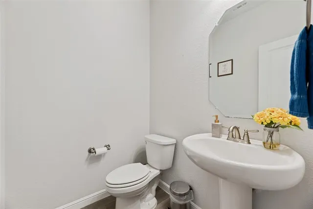 a bathroom with a sink mirror and toilet