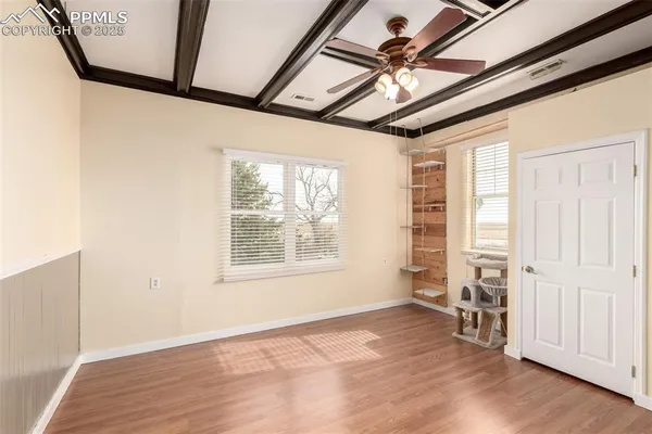 an empty room with wooden floor and windows