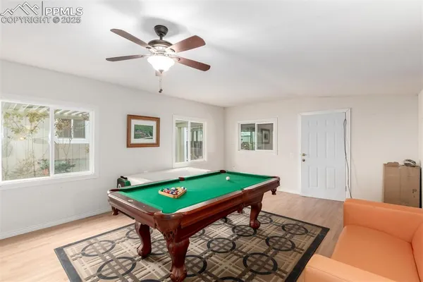 a room with pool table and windows