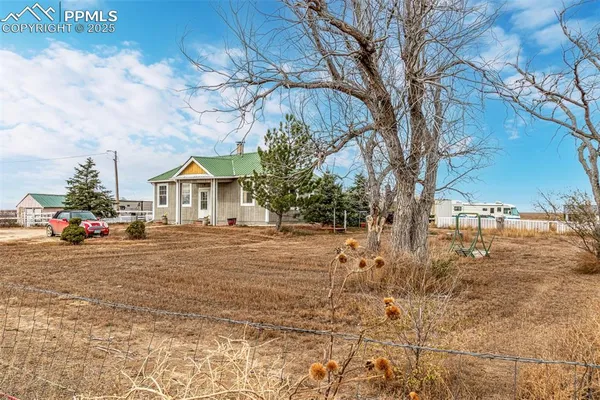 a front view of house with yard and trees in the background