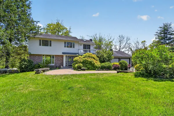 a view of a house with a yard and sitting area