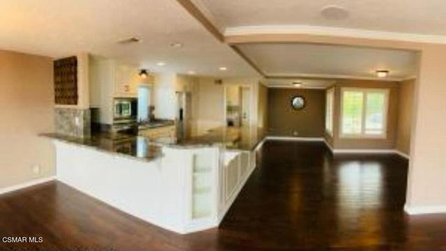 a view of a hallway with wooden floor and furniture