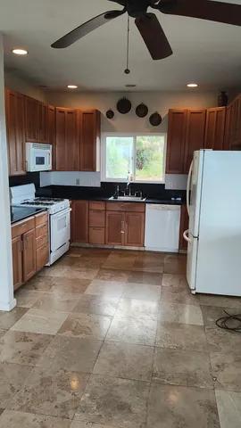 a large kitchen with stainless steel appliances granite countertop a stove a sink a refrigerator and a cabinets