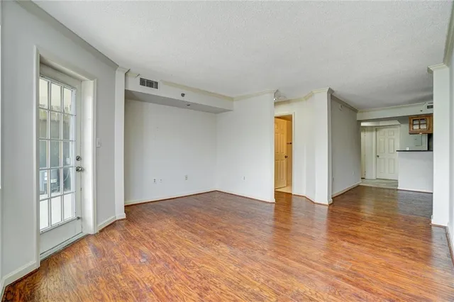 an empty room with wooden floor and a ceiling fan