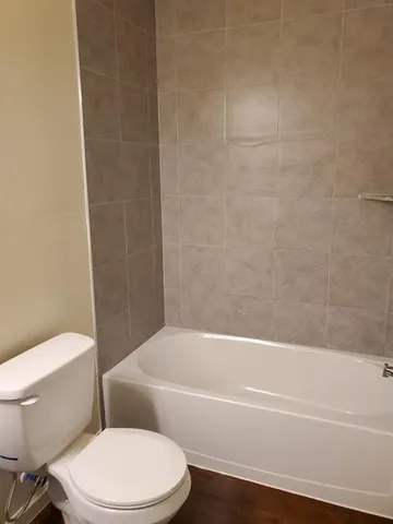 a white toilet and tub sitting next to a bathroom sink