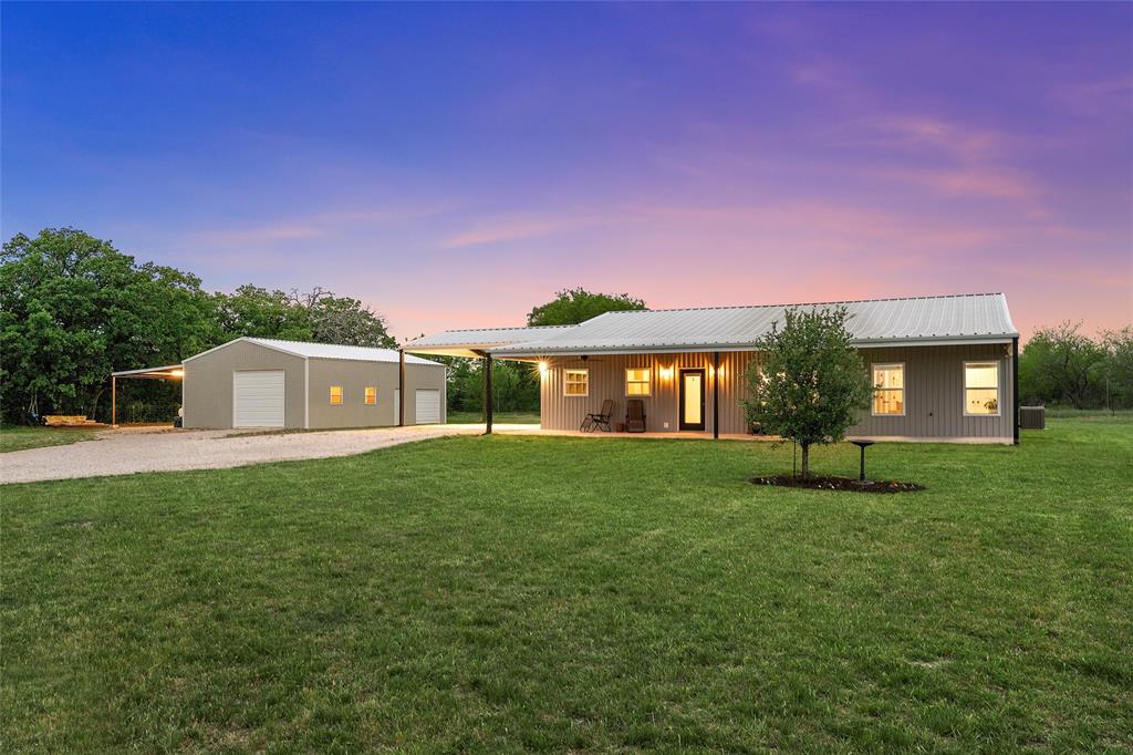 1125 Water Tower Road Axtell, TX 76624 - Photo 1 of 1 Single story home featuring gravel driveway, an outdoor structure, a front yard, and a garage