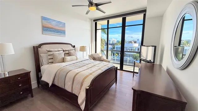 a bedroom with a bed a mirror and a large window