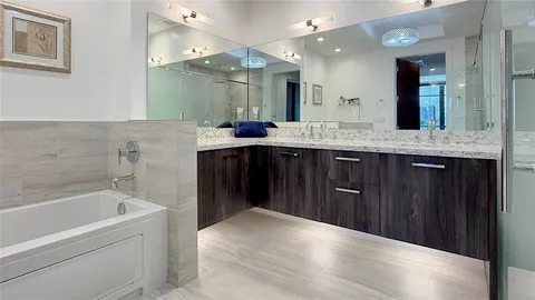 a spacious bathroom with a granite countertop sink a toilet a mirror a bathtub and shower
