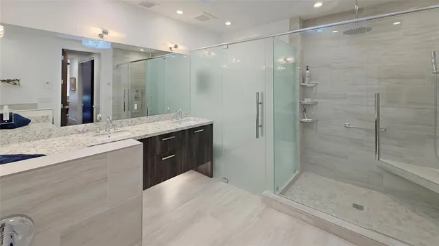 a bathroom with a shower sink and mirror
