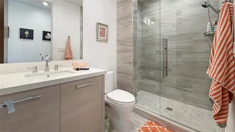 a bathroom with a sink a toilet and shower