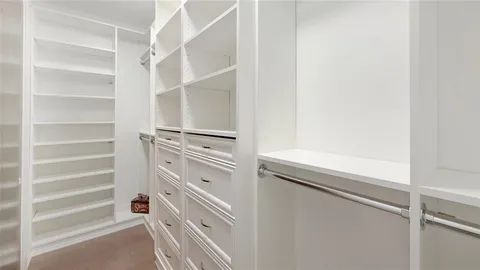 a view of walk in closet with empty racks