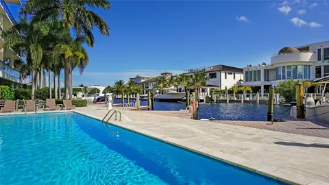 a swimming pool with outdoor seating and a garden