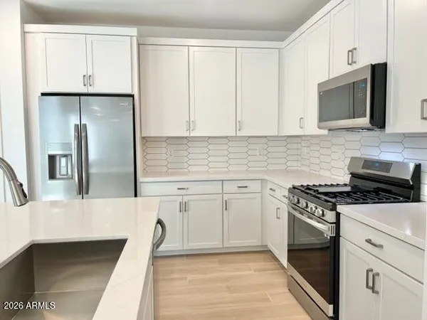 a kitchen with stainless steel appliances granite countertop a stove a sink and a refrigerator
