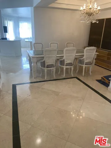 a room with chairs and view of kitchen