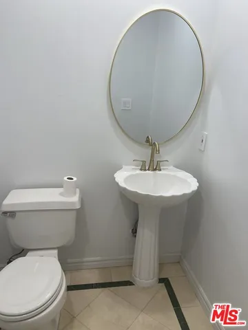 a bathroom with a sink toilet and a mirror