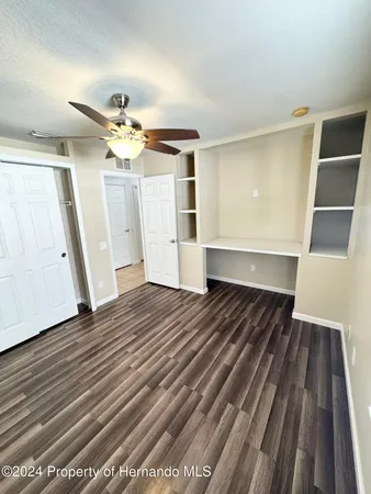 a view of a room with wooden floor and ceiling fan