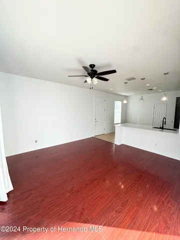 a view of a livingroom with a ceiling fan and wooden floor