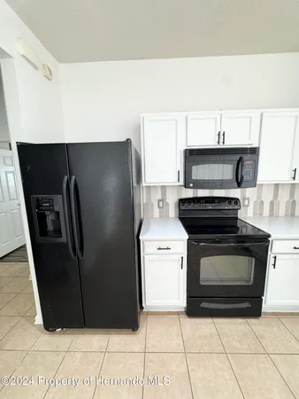 a kitchen with a refrigerator and a stove