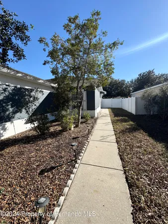 a pathway of a house with a yard