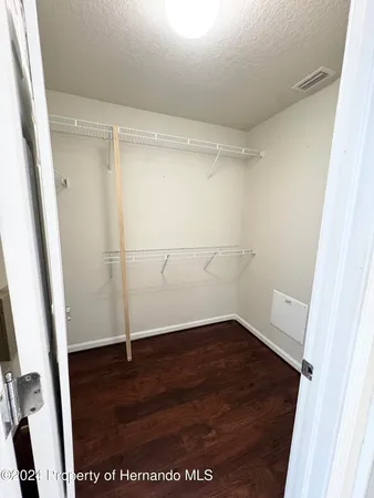 an empty room with wooden floor and white door