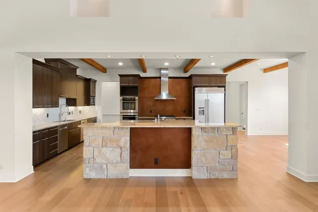 a kitchen with stainless steel appliances granite countertop a stove a sink and a refrigerator