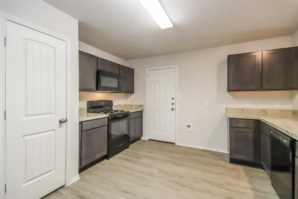 a kitchen with stainless steel appliances granite countertop a stove a sink and a refrigerator