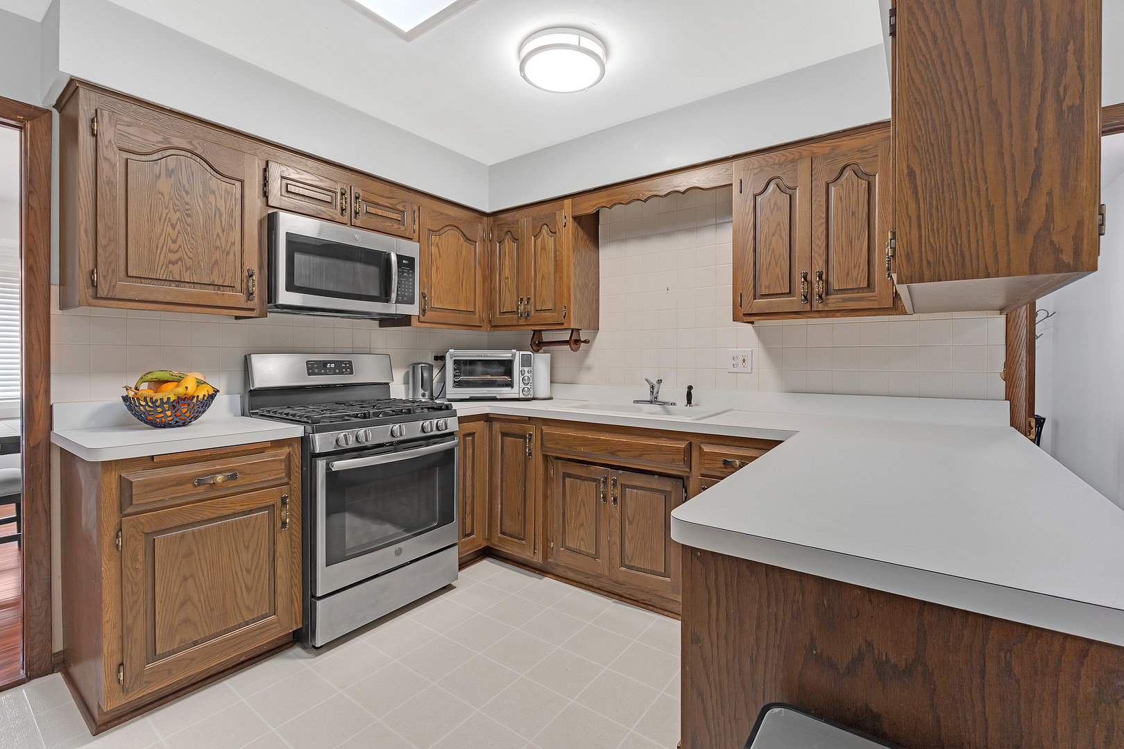 11020 Raleigh Street Westchester, IL 60154 - Photo 9 of 27 a kitchen with stainless steel appliances granite countertop a sink stove and microwave