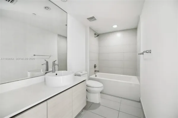 a bathroom with a bathtub shower sink vanity and toilet