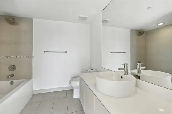 a bathroom with a white bath tub a toilet and a sink