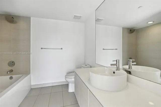 a bathroom with a white bath tub a toilet and a sink