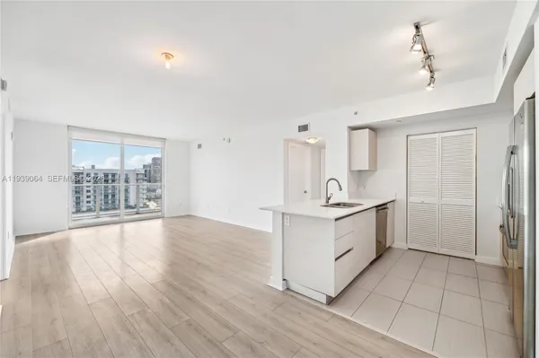 a view of a kitchen with a sink and wooden floor