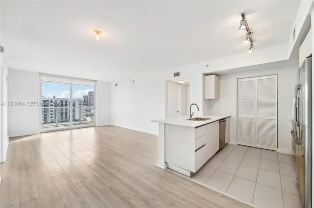 a view of a kitchen with a sink and wooden floor