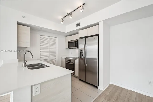a kitchen with granite countertop a refrigerator and a sink