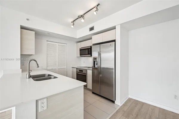 a kitchen with granite countertop a refrigerator and a sink