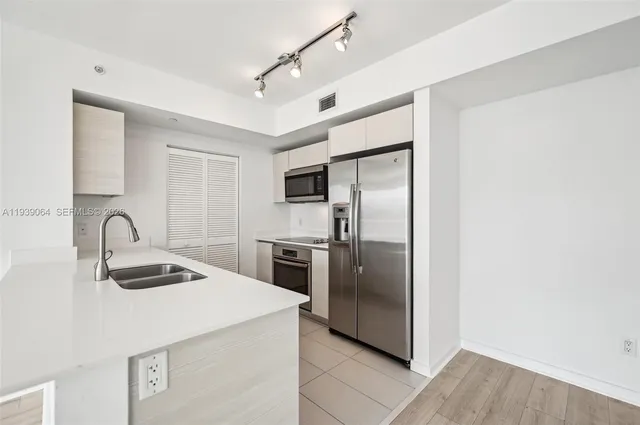 a kitchen with granite countertop a refrigerator and a sink