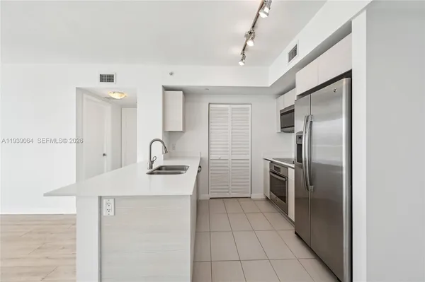 a kitchen with a sink stainless steel appliances and cabinets