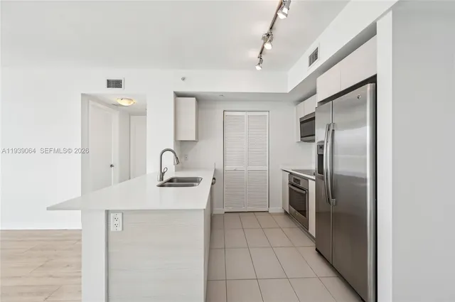 a kitchen with a sink stainless steel appliances and cabinets