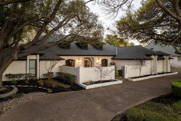 a front view of a house with yard and parking