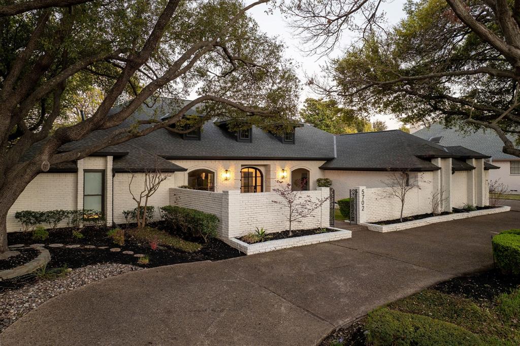 a front view of a house with yard and parking