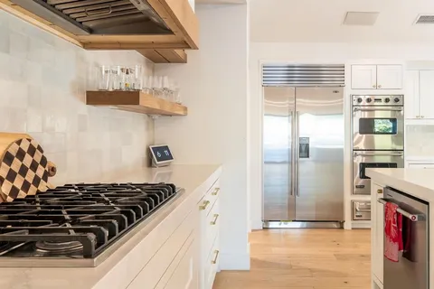 a kitchen with white cabinets and a refrigerator