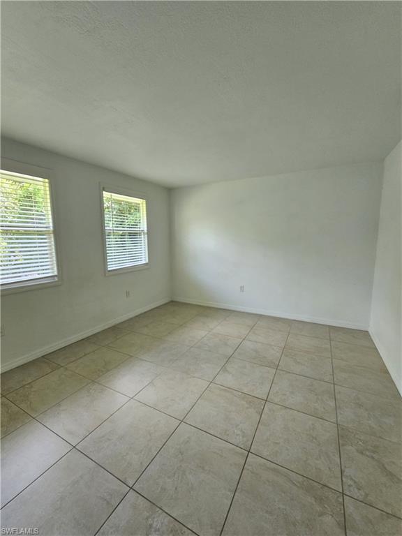828 96th Avenue North, Unit B Naples, FL 34108 - Photo 11 of 13 Spare room with a textured ceiling and light tile patterned flooring