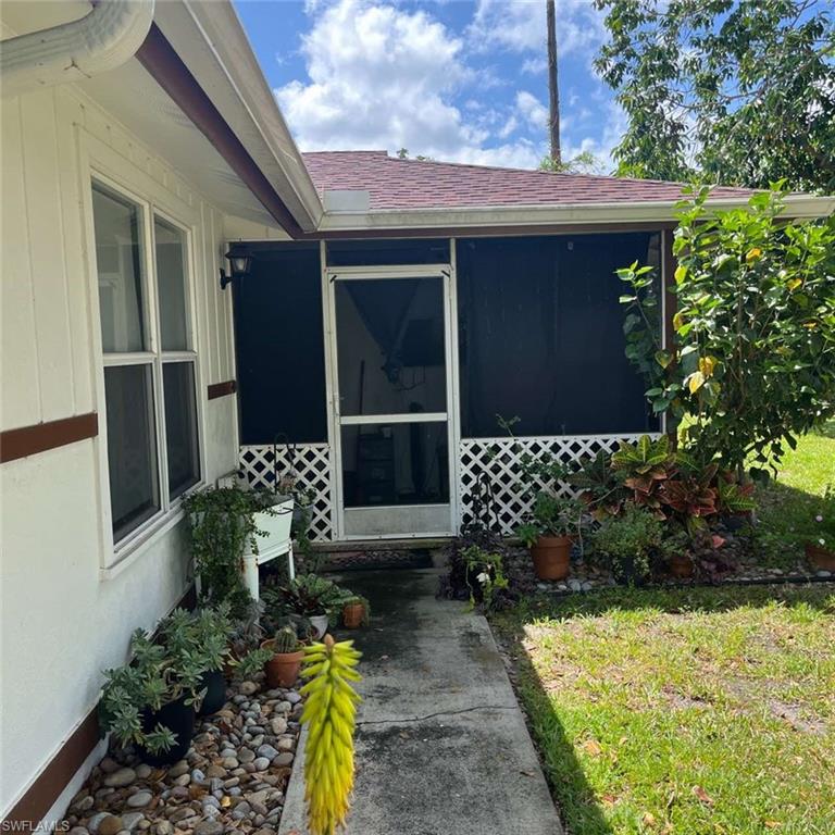 828 96th Avenue North, Unit B Naples, FL 34108 - Photo 2 of 13 View of exterior entry with a shingled roof