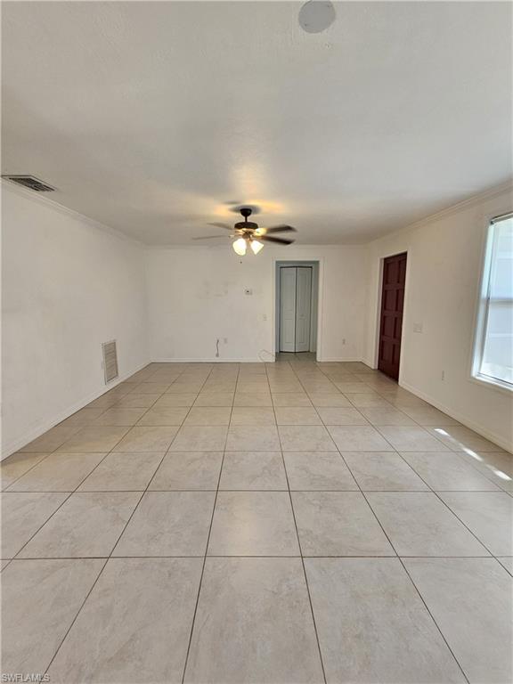 828 96th Avenue North, Unit B Naples, FL 34108 - Photo 3 of 13 Unfurnished room with a ceiling fan, light tile patterned floors, and crown molding