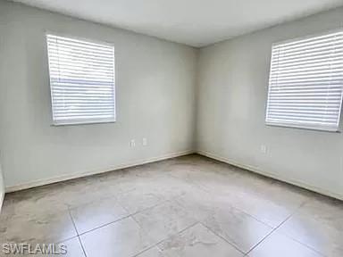 828 96th Avenue North, Unit B Naples, FL 34108 - Photo 8 of 13 Tiled spare room featuring plenty of natural light and baseboards