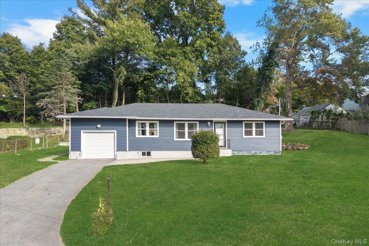 a front view of a house with a garden and trees