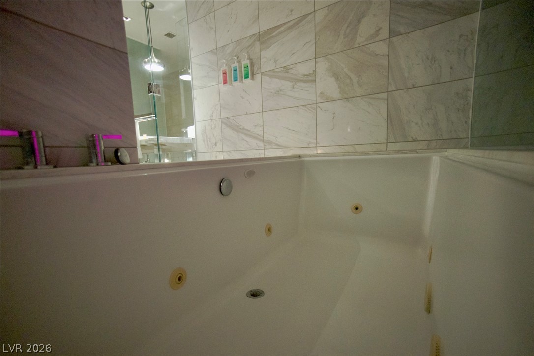 4381 West Flamingo Road, Unit 3616 Las Vegas, NV 89103 - Photo 12 of 29 Luxurious jetted tub awaits, offering a tranquil escape within this modern bathroom.