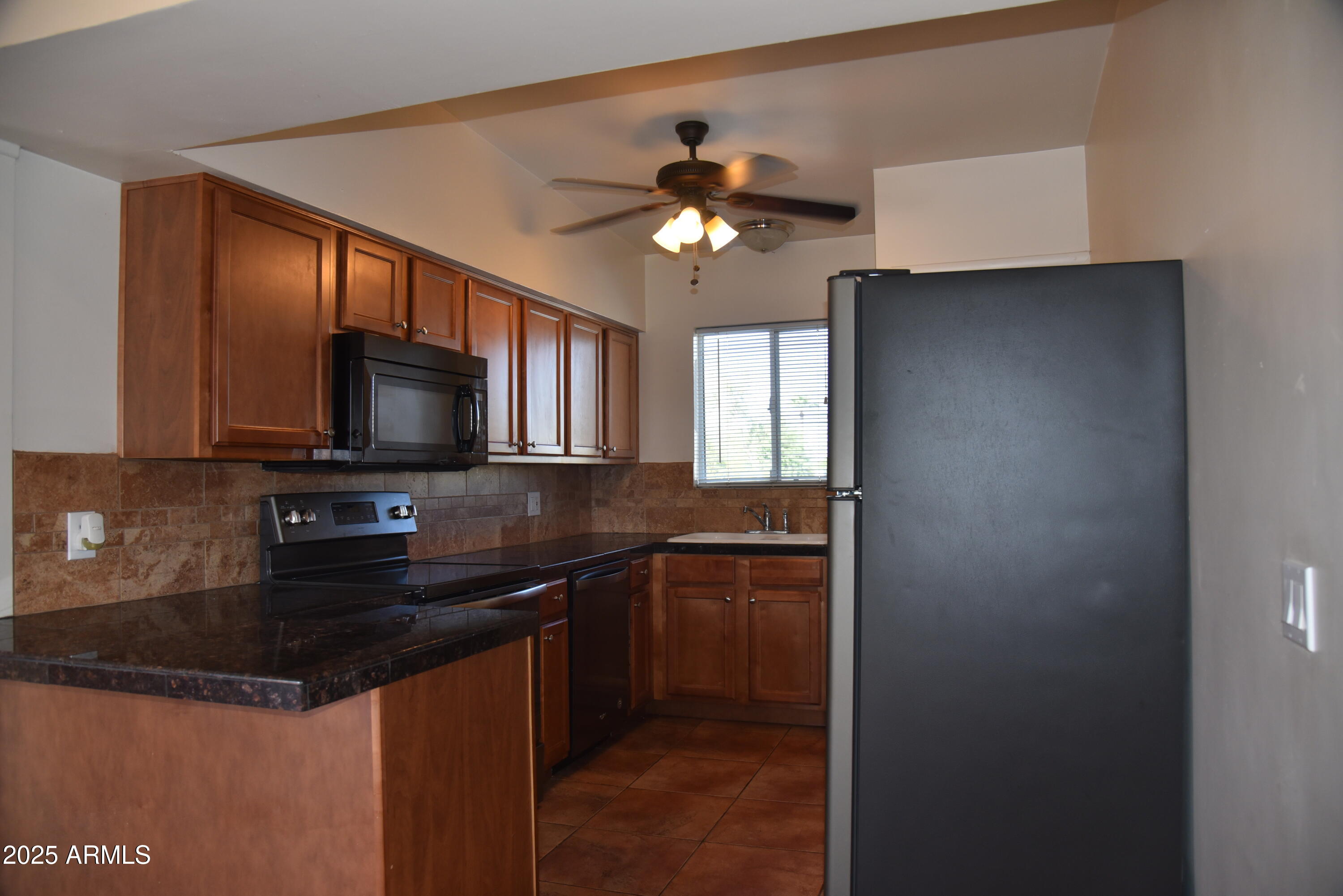 a kitchen with granite countertop a sink stainless steel appliances and cabinets