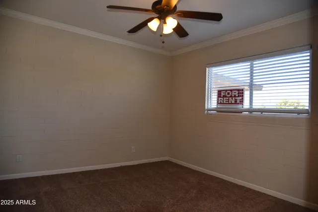 an empty room with a window and a fan