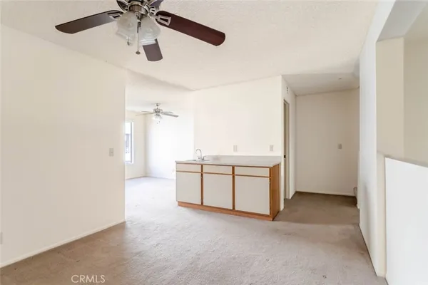 an empty room with a ceiling fan and a window