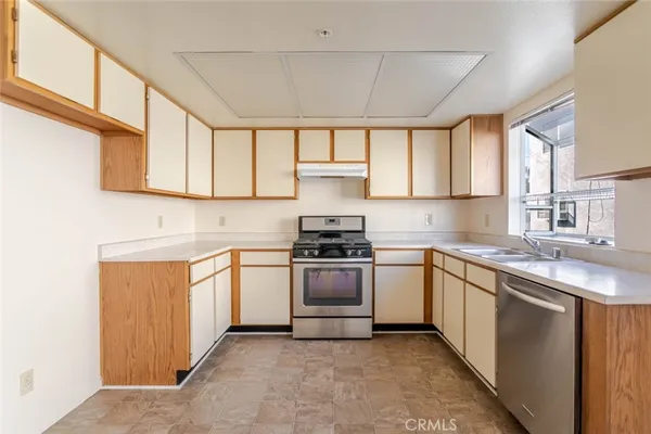 a kitchen with stainless steel appliances granite countertop a sink stove and cabinets